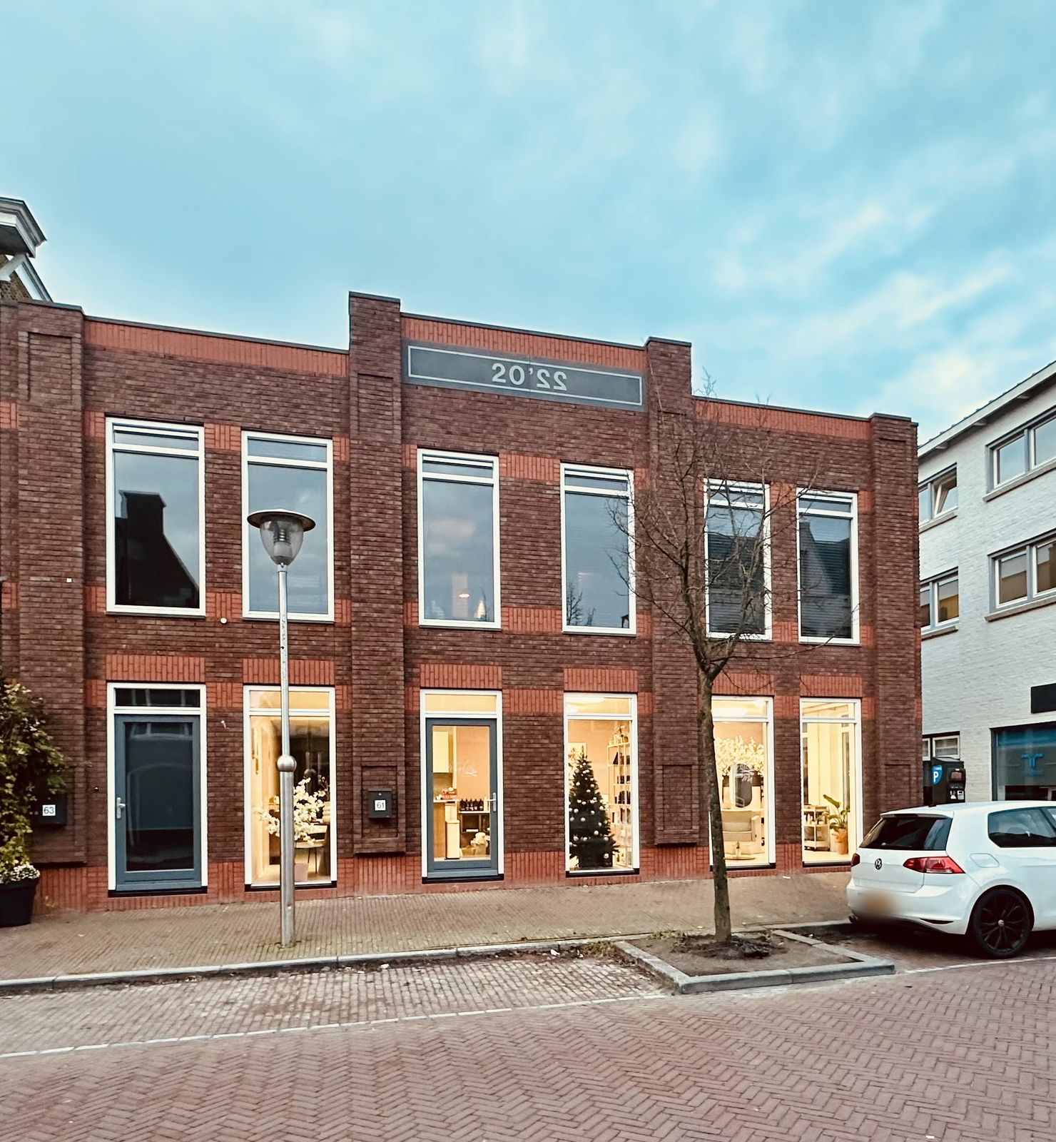 De gevel aan de Oude Koemarkt 61, met de verlichte ramen van de salon